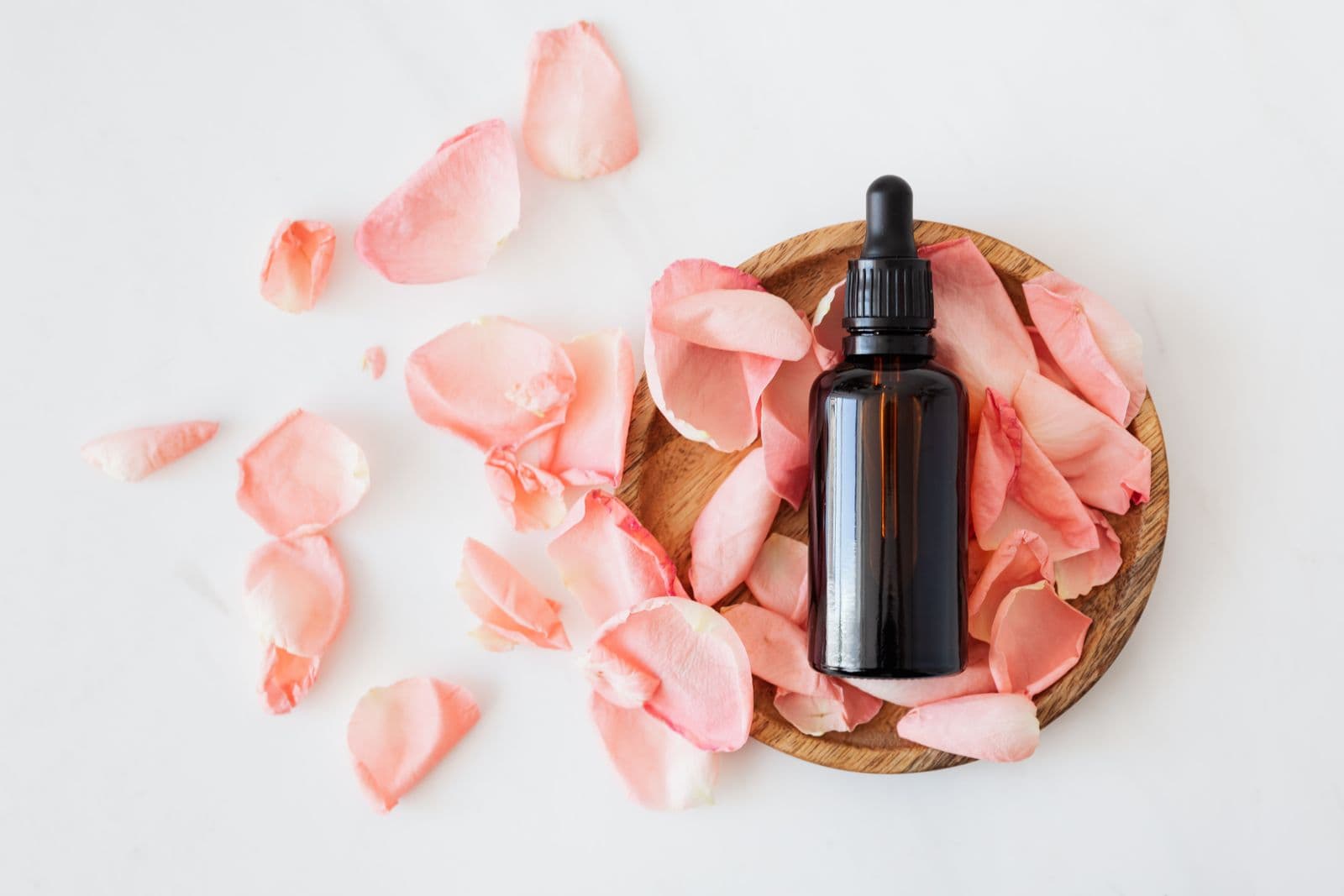 Nuru gel — rose petals and warm amber oil on marble