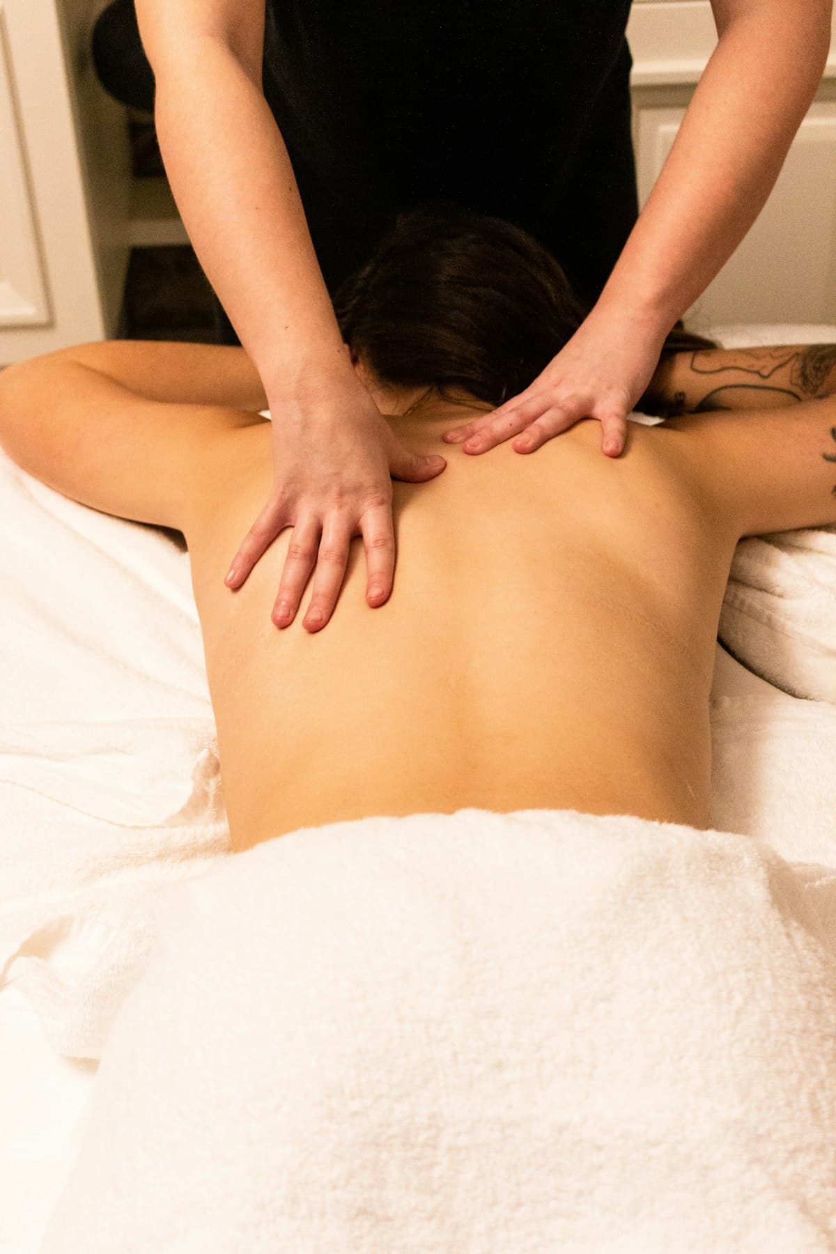 Therapist applying firm pressure to the upper back