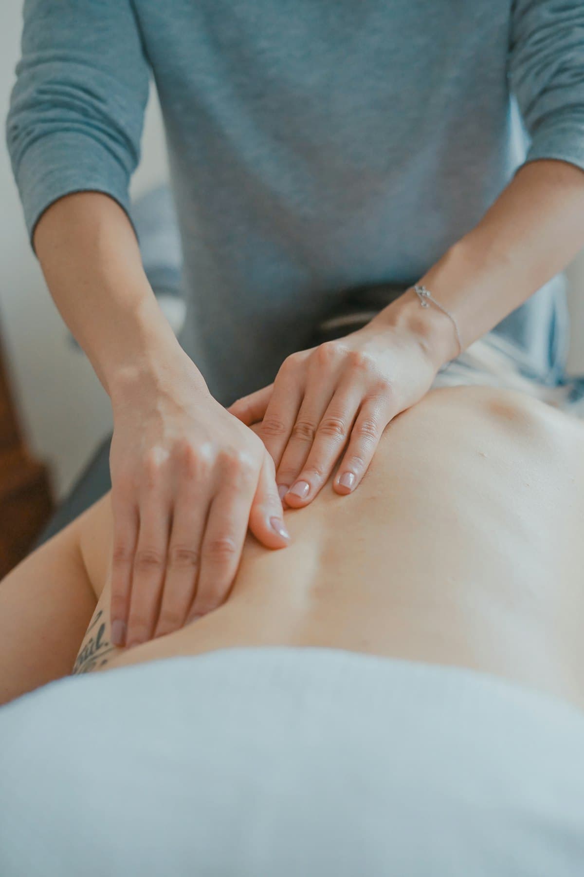 Palm pressure along the back during Balinese-style massage