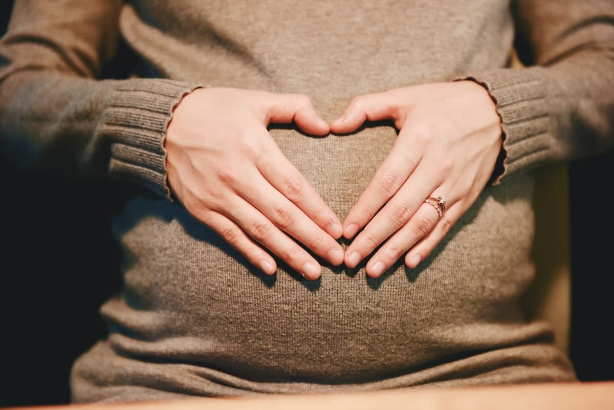 Pregnancy-safe care — hands over a baby bump
